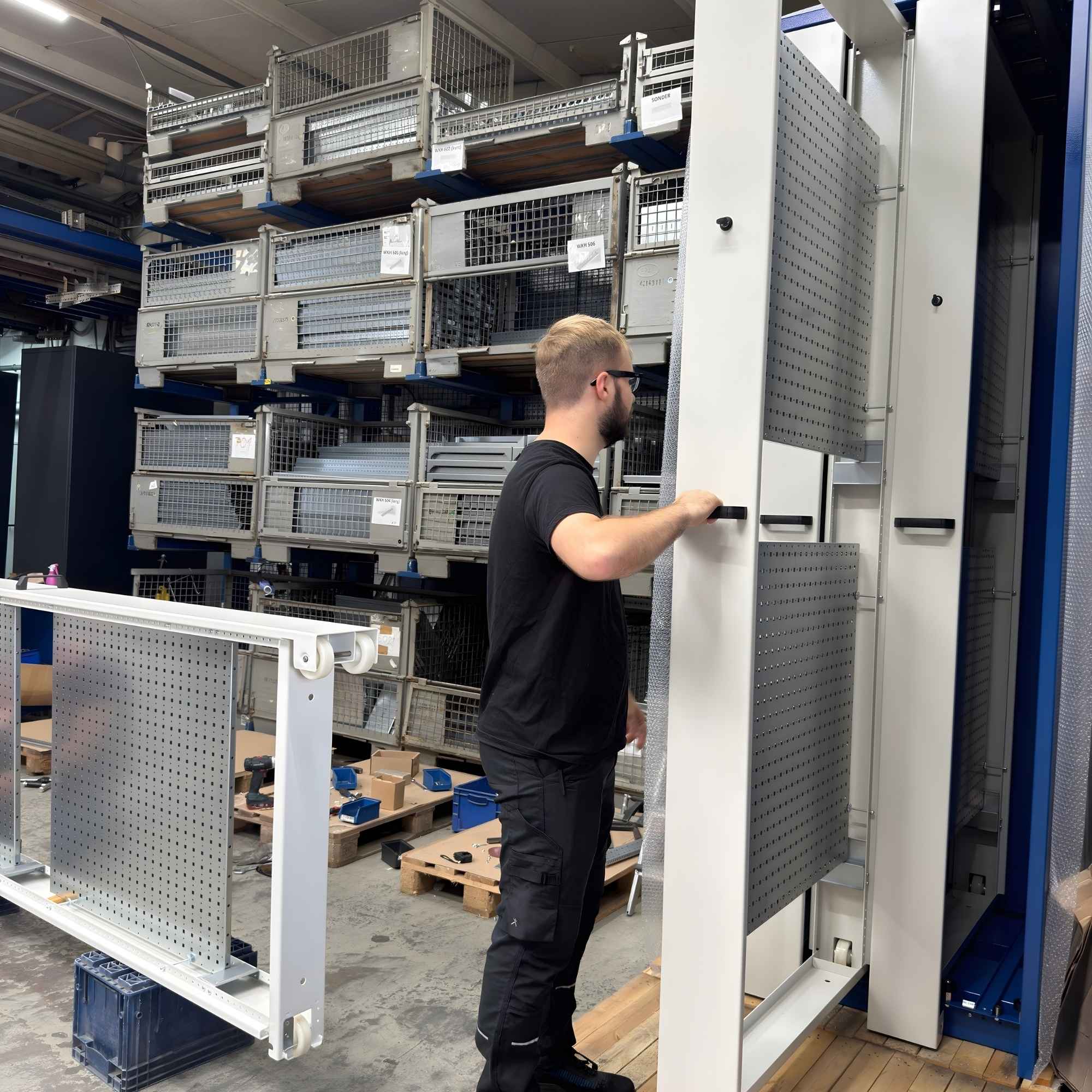 Mitarbeiter an Werkzeugschrank mit geteilter Lochblechwand in Sonderhöhe